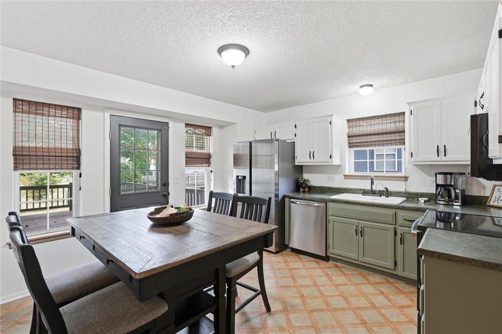 Two-tone kitchen cabinets and breakfast nook at 1302 Deena Street, Pleasant Hill, MO 64080