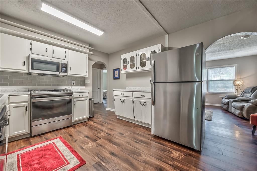Open floor plan, white kitchen and stainless steel appliances at 8425 Boone Street, Kansas City, MO 64114