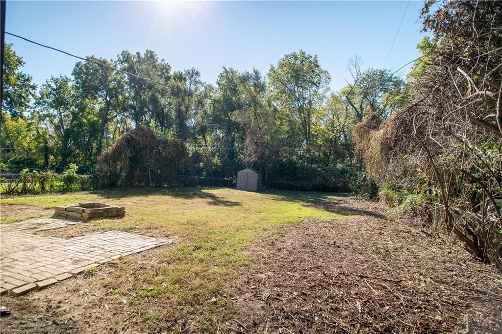Big backyard, mature trees and fire pit at 3201 Hagemann Street, Kansas City, KS 66106