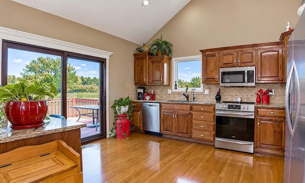Granite counters, stainless steel appliances and wood kitchen cabinets at 993 Sicklebar Drive, Peculiar, MO 64078