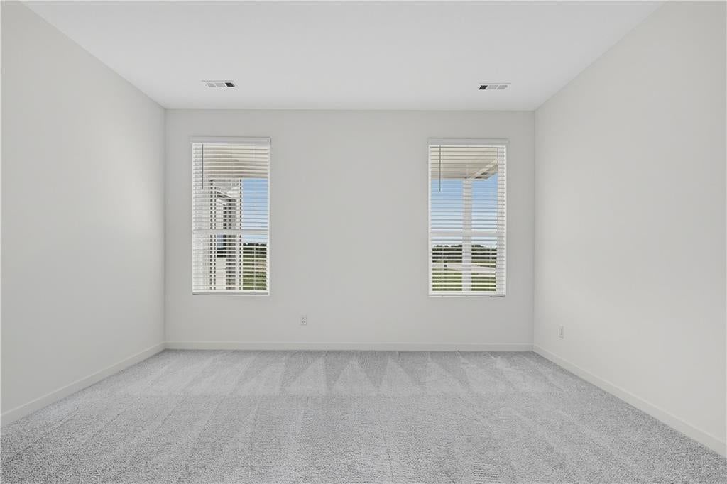 Main-floor primary bedroom and carpet at 4108 NE Apple Grove Drive, Lee's Summit, MO 64064