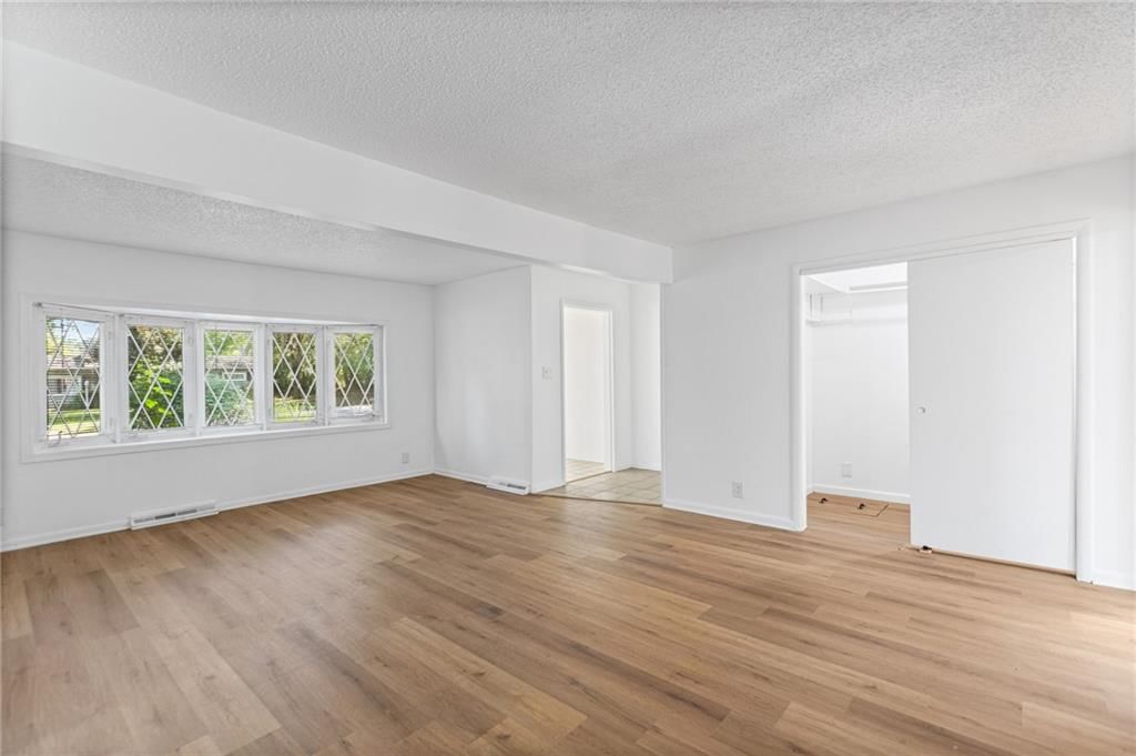 Main-floor primary bedroom, hardwood floors and white trim at 6912 N Harrison Street, Gladstone, MO 64118