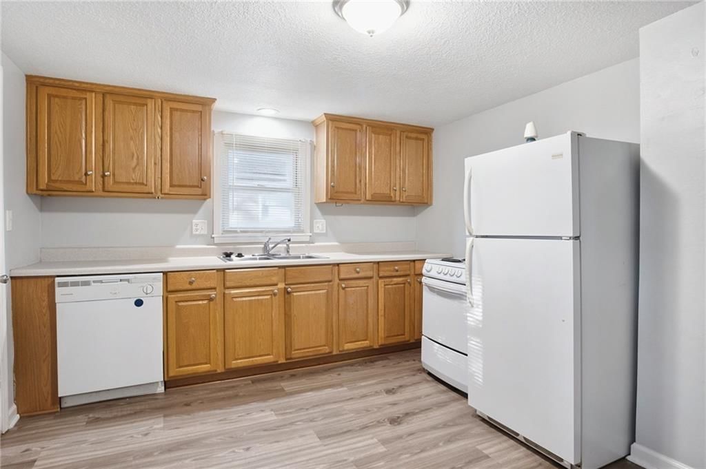 Wood kitchen cabinets, white appliances and electric range at 2316 Blue Ridge Terrace, Independence, MO 64052