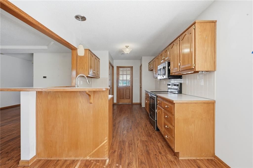 Wood kitchen cabinets, kitchen backsplash and subway tile backsplash at 502 S Saturn Drive, Raymore, MO 64083