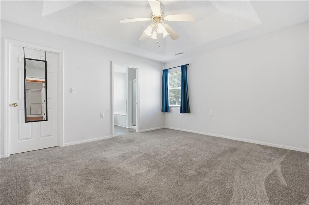 Main-floor primary bedroom and carpet at 502 S Saturn Drive, Raymore, MO 64083