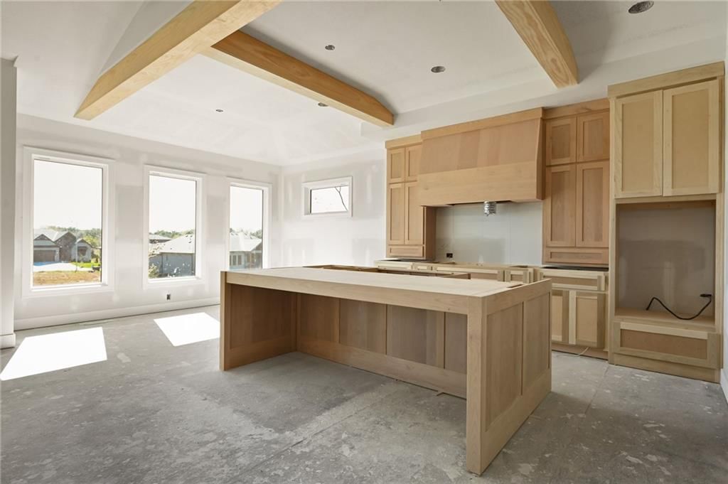 Tall ceilings, kitchen island and ceiling beams at 905 Savannah Lane, Greenwood, MO 64034