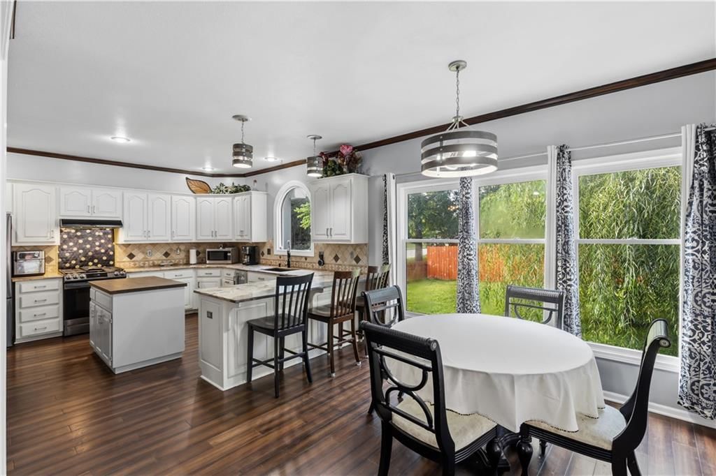 Kitchen island, white kitchen and granite counters at 7407 Marion Avenue, Kansas City, MO 64133