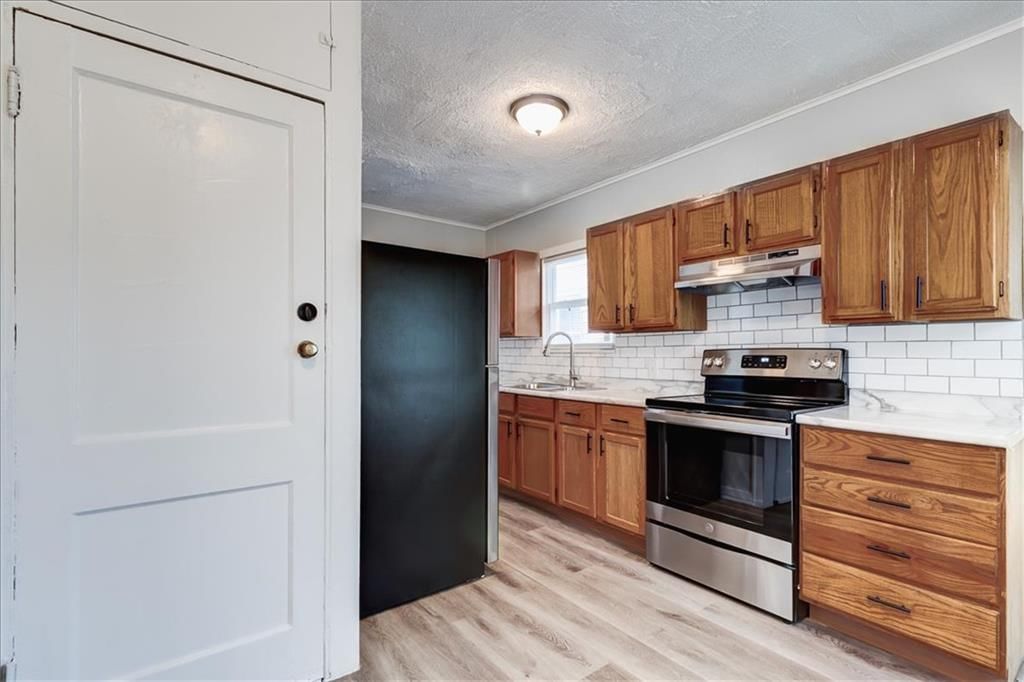 Stainless steel appliances, wood kitchen cabinets and electric range at 6015 Park Avenue, Kansas City, MO 64130