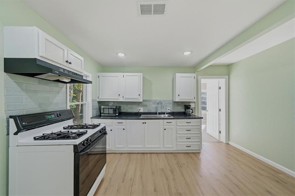 White kitchen, gas range and kitchen backsplash at 4311 Bales Avenue, Kansas City, MO 64130