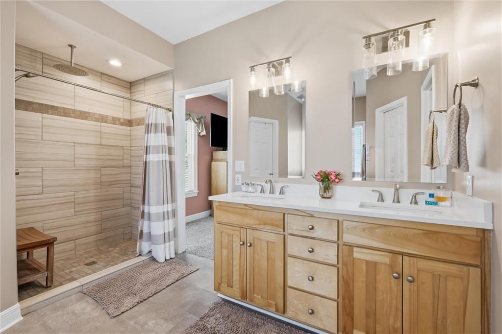Walk-in shower, tiled shower and double vanity at 27423 New Lancaster Road, Louisburg, KS 66053