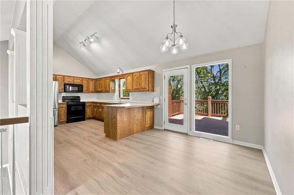 Open floor plan, kitchen island and statement lighting at 9504 NW 87th Terrace, Kansas City, MO 64153