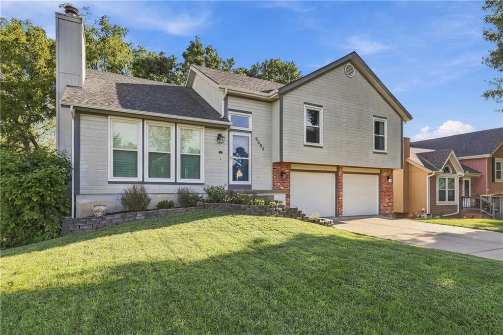 Attached garage, gray roof and asphalt shingle roof at 9504 NW 87th Terrace, Kansas City, MO 64153