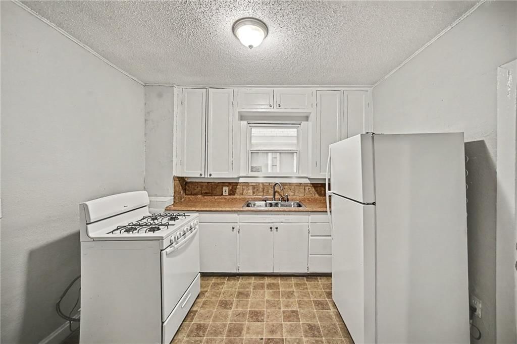 White kitchen, gas range and white appliances at 1603 Elmwood Street, Kansas City, MO 64127