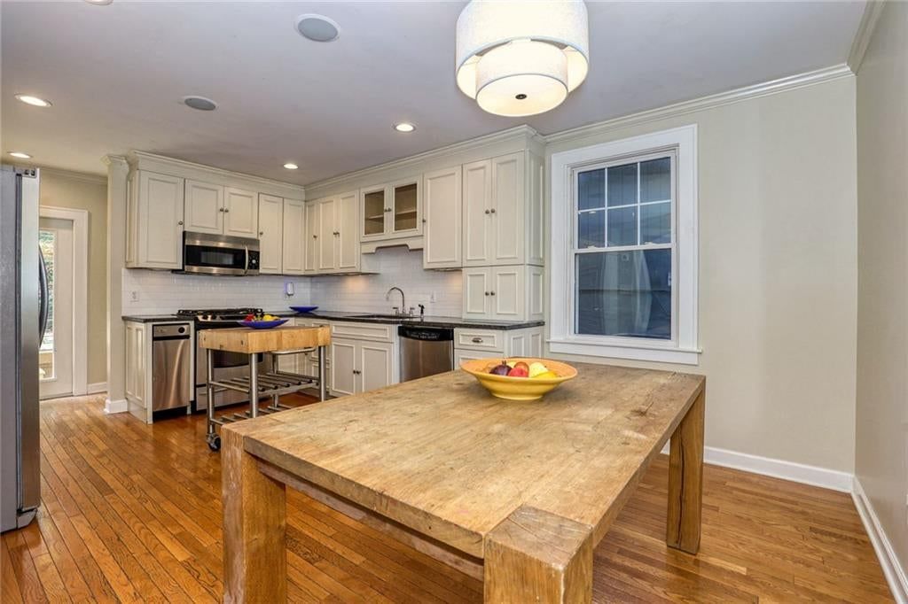 Kitchen island, white kitchen and gas range at 4900 Westwood Road, Kansas City, MO 64112
