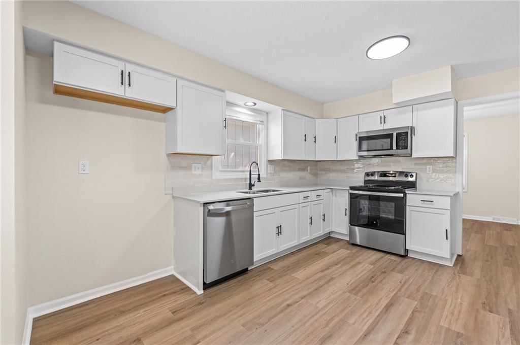 White kitchen, shaker cabinets and stainless steel appliances at 14710 NW 67th Street, Parkville, MO 64152