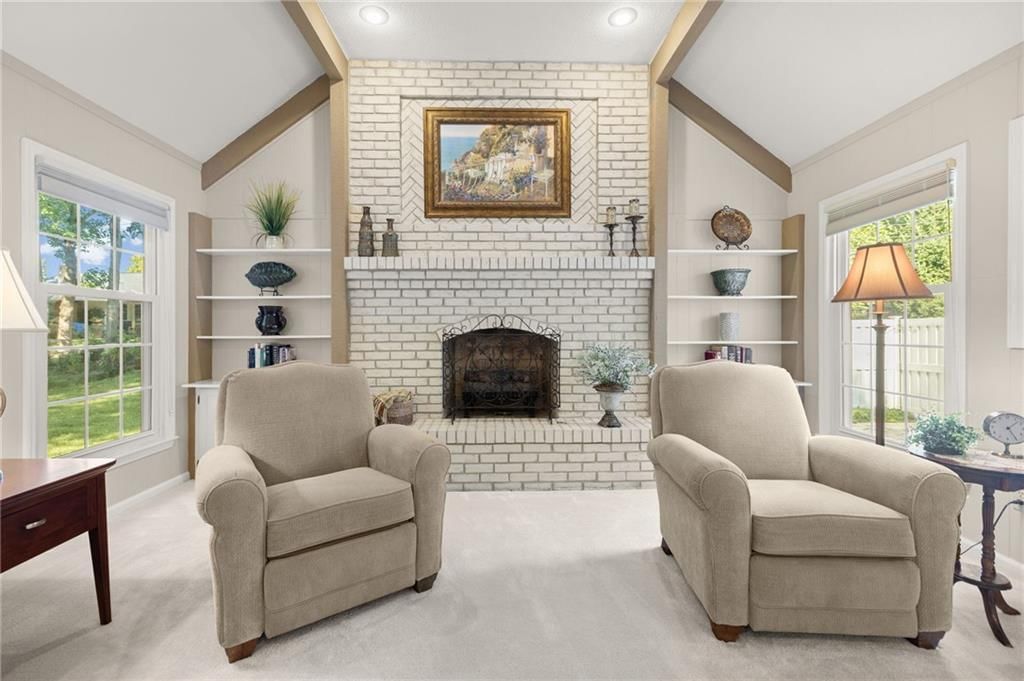 Open floor plan, ceiling beams and brick fireplace at 7812 W 100th Terrace, Overland Park, KS 66212