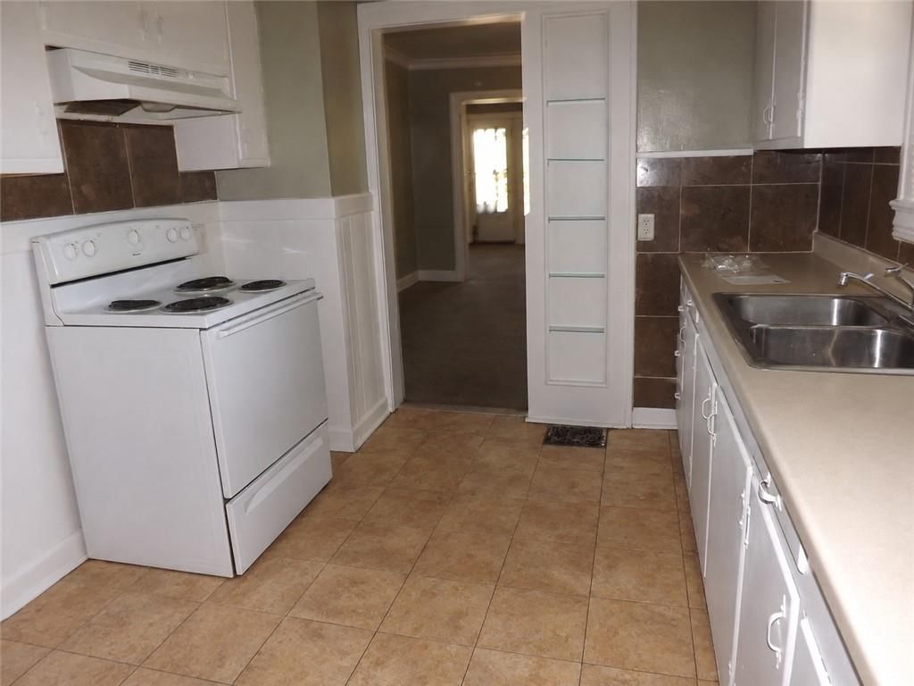 White kitchen cabinets, tile floors and white appliances at 340 Elmwood Avenue, Kansas City, MO 64124