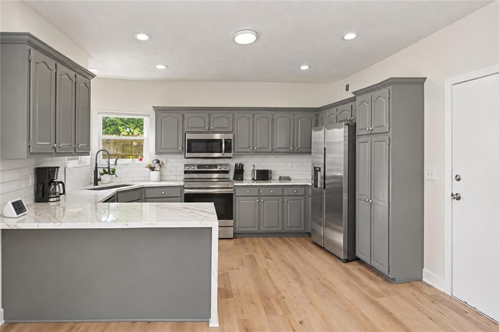 Kitchen island, quartz counters and gray kitchen cabinets at 20831 W 102nd Street, Lenexa, KS 66220
