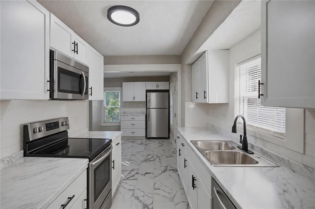 White kitchen, stainless steel appliances and updated kitchen at 4223 Agnes Avenue, Kansas City, MO 64130
