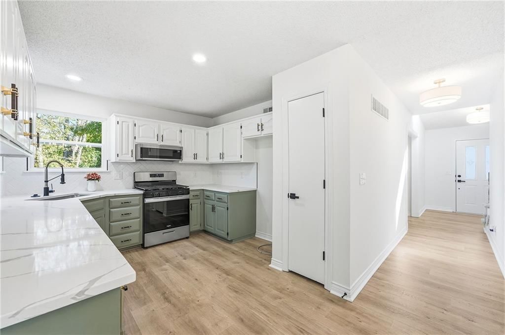 Gas range, two-tone kitchen cabinets and stainless steel appliances at 1436 N Anne Shirley Drive, Olathe, KS 66061