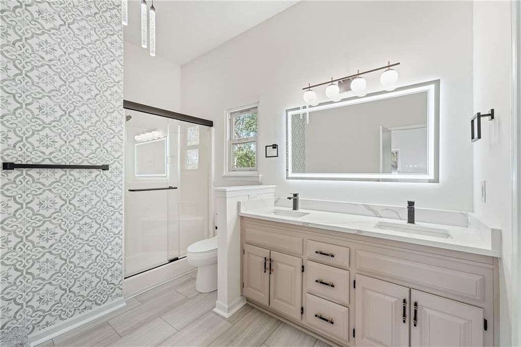 Tiled shower, double vanity and renovated bathrooms at 1436 N Anne Shirley Drive, Olathe, KS 66061