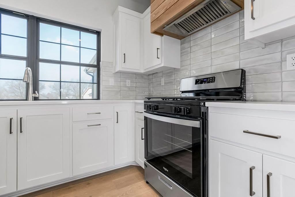 Kitchen island, white kitchen and gas range at 2313 Larkspur Lane, Kearney, MO 64060