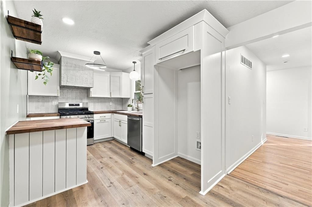White kitchen, statement lighting and wainscoting or board and batten at 15401 E 36th Street S, Independence, MO 64055