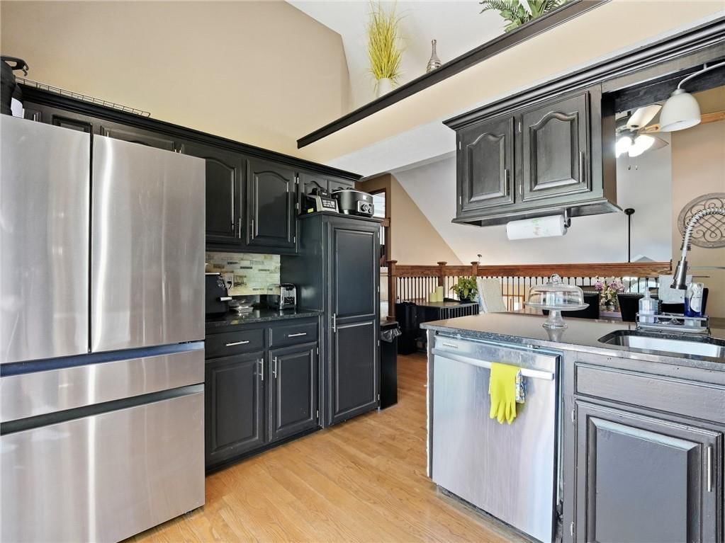 Kitchen island, hardwood floors and kitchen backsplash at 337 NE Dreamweaver Avenue, Lee's Summit, MO 64086