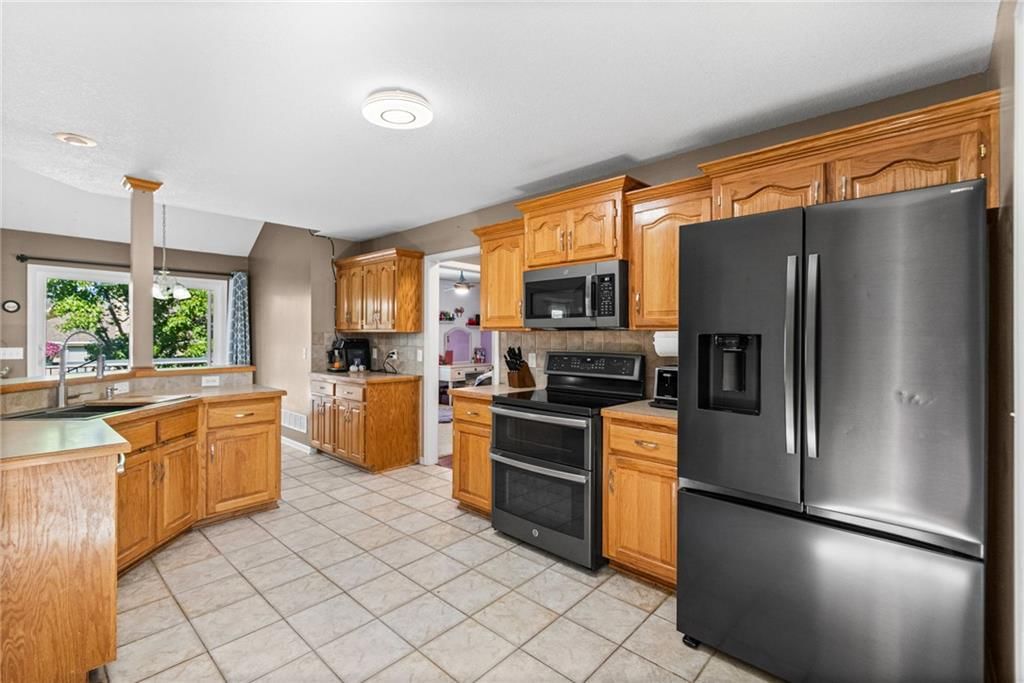 Kitchen island, double oven and kitchen backsplash at 13470 Timber Park Lane, Platte City, MO 64079