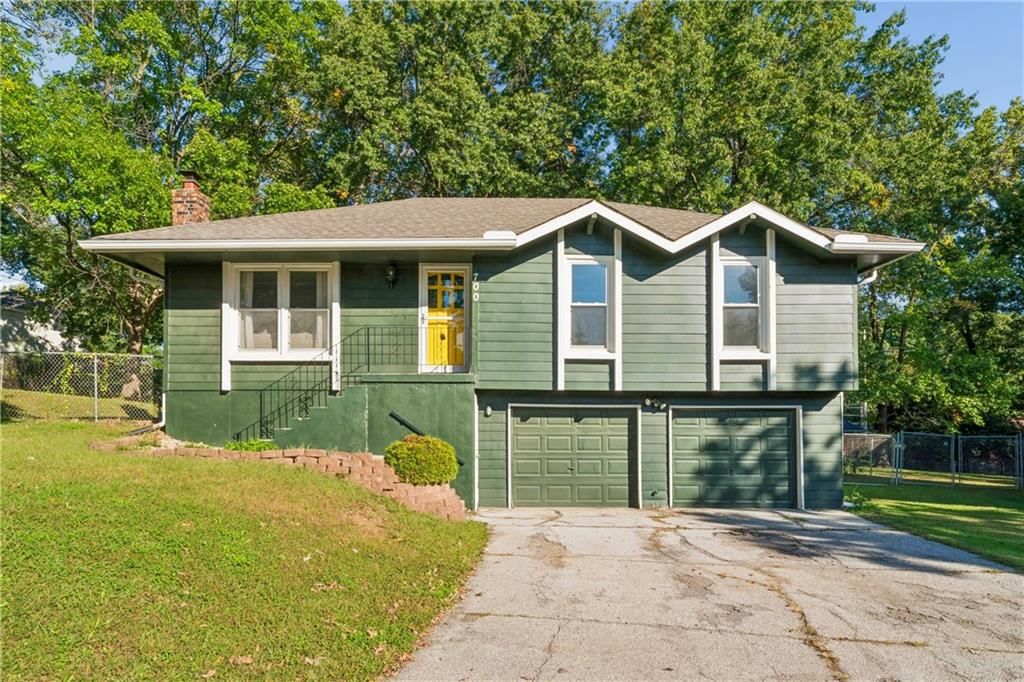 Fenced yard, mature trees and attached garage at 700 NE 55TH Street, Kansas City, MO 64118