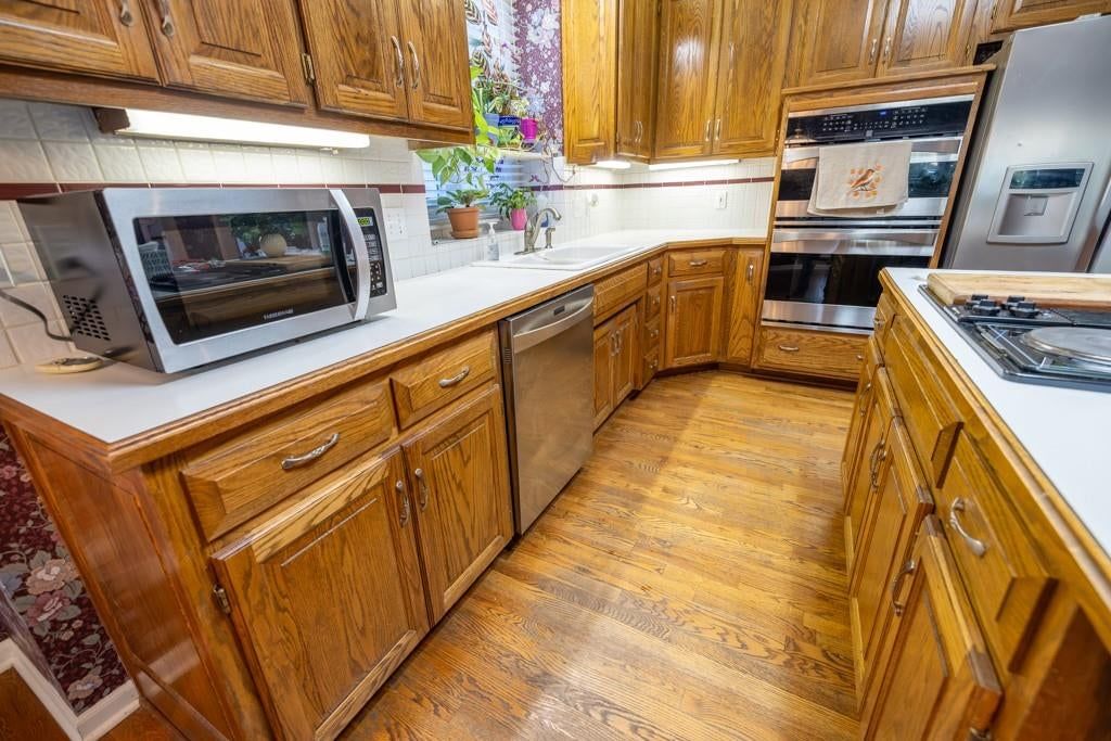 Open floor plan, kitchen island and hardwood floors at 4990 W 178th Terr, Stilwell, KS 66085