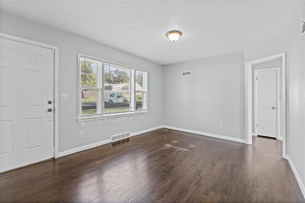 Main-floor primary bedroom, hardwood floors and white trim at 10137 E 80th Street, Raytown, MO 64138