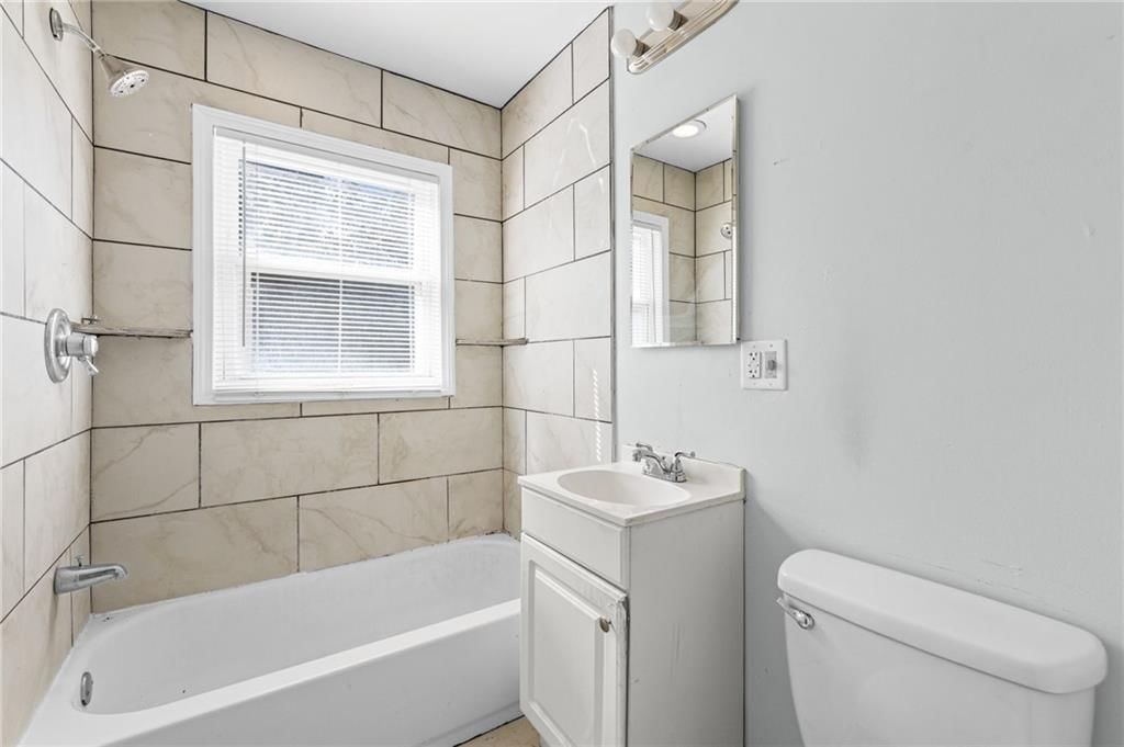 Tiled shower and white vanity at 10137 E 80th Street, Raytown, MO 64138