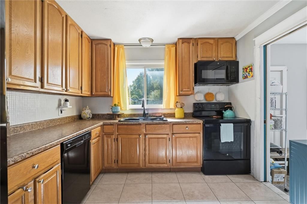 Tile floors, wood kitchen cabinets and electric range at 725 W Elm Street, Olathe, KS 66061