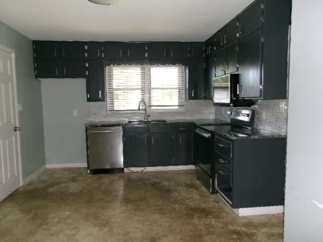 Stainless steel appliances, kitchen backsplash and dark kitchen cabinets at 3811 S Delaware Avenue, Independence, MO 64055