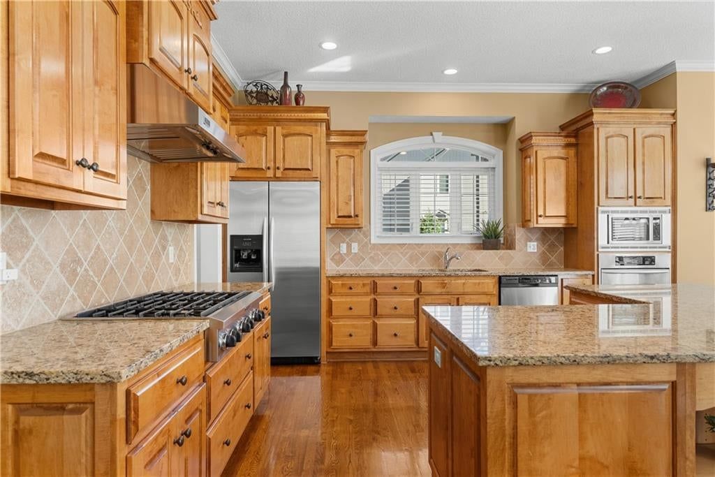 Granite counters, double oven and kitchen backsplash at 311 NW Rockwood Court, Lee's Summit, MO 64081