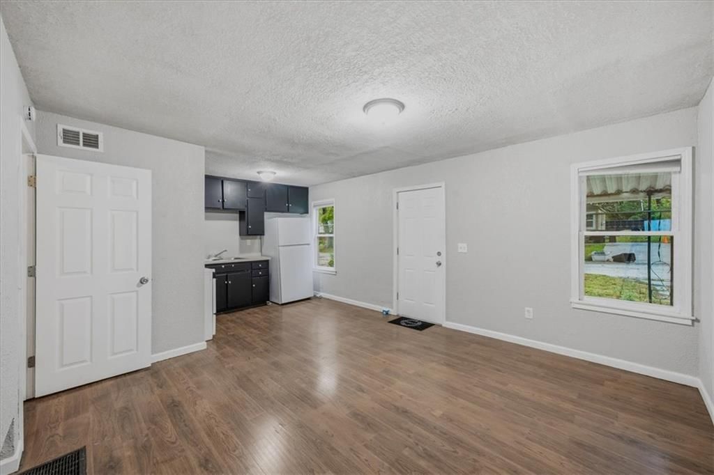 Main-floor primary bedroom and black kitchen cabinets at 11005 E (&11007) 19th Street, Independence, MO 64052