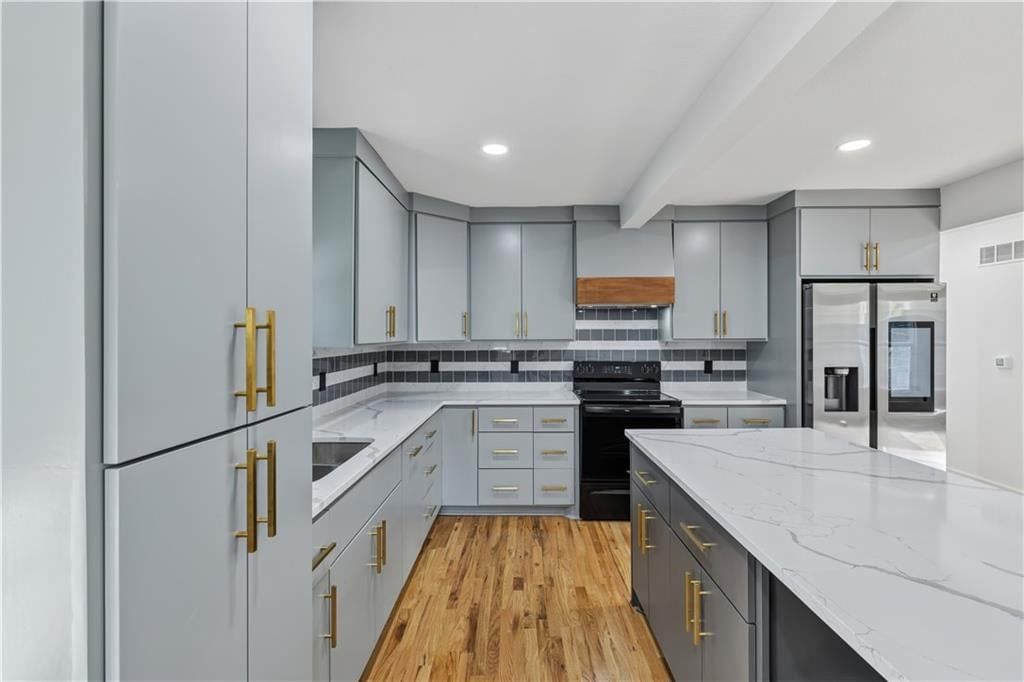 Kitchen island, quartz counters and gray kitchen cabinets at 3410 Barnett Avenue, Kansas City, KS 66102
