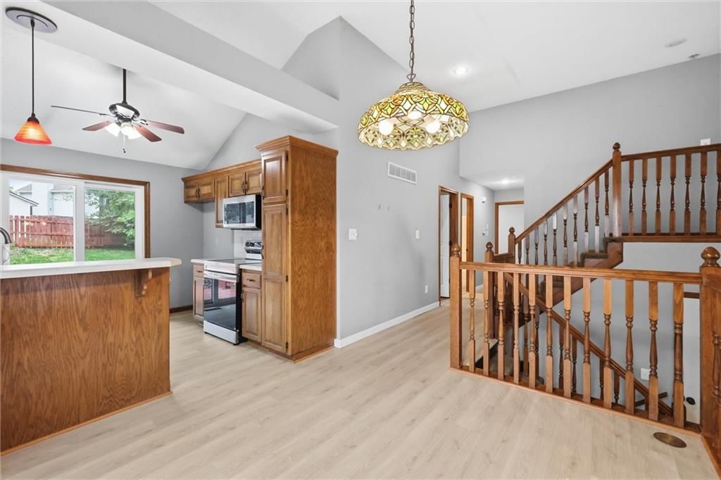 Open floor plan, stainless steel appliances and wood kitchen cabinets at 701 NW Rosaceae Drive, Blue Springs, MO 64015