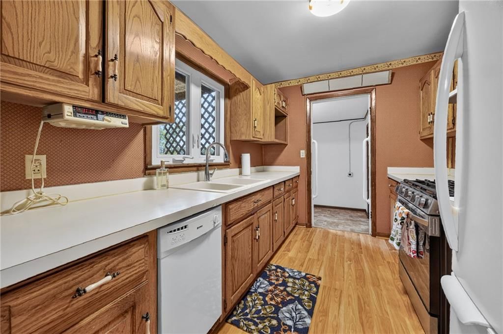 Gas range, wood kitchen cabinets and white appliances at 29602 D Highway, Lawson, MO 64062