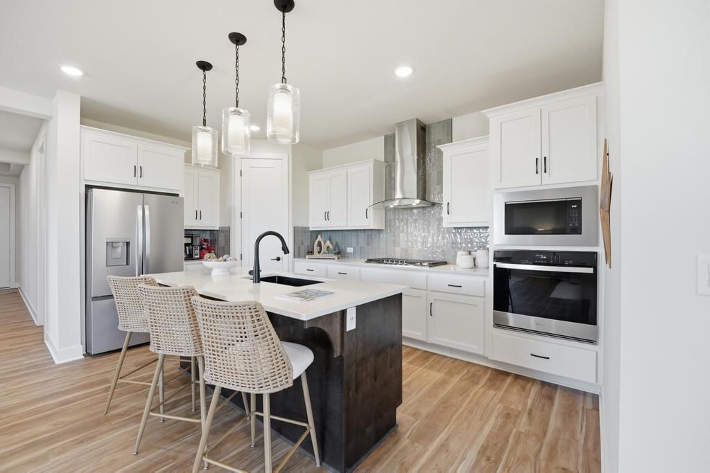 Kitchen island, white kitchen and walk-in pantry at 17690 Jubilee Street, Gardner, KS 66030