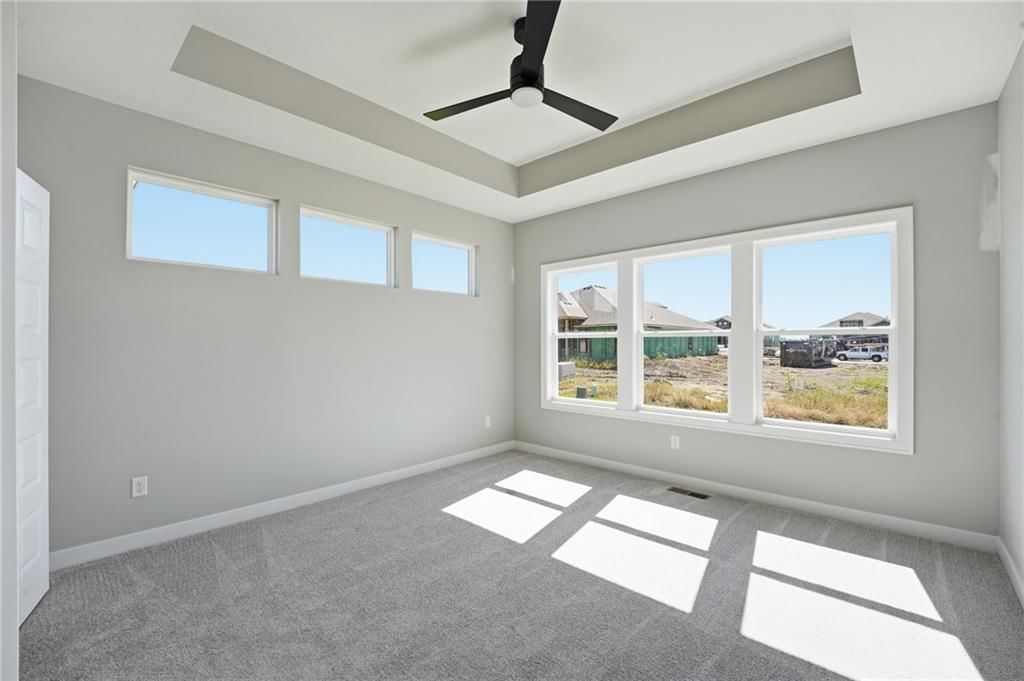 Main-floor primary bedroom, tray ceiling and carpet at 18585 W 195th Street, Spring Hill, KS 66083