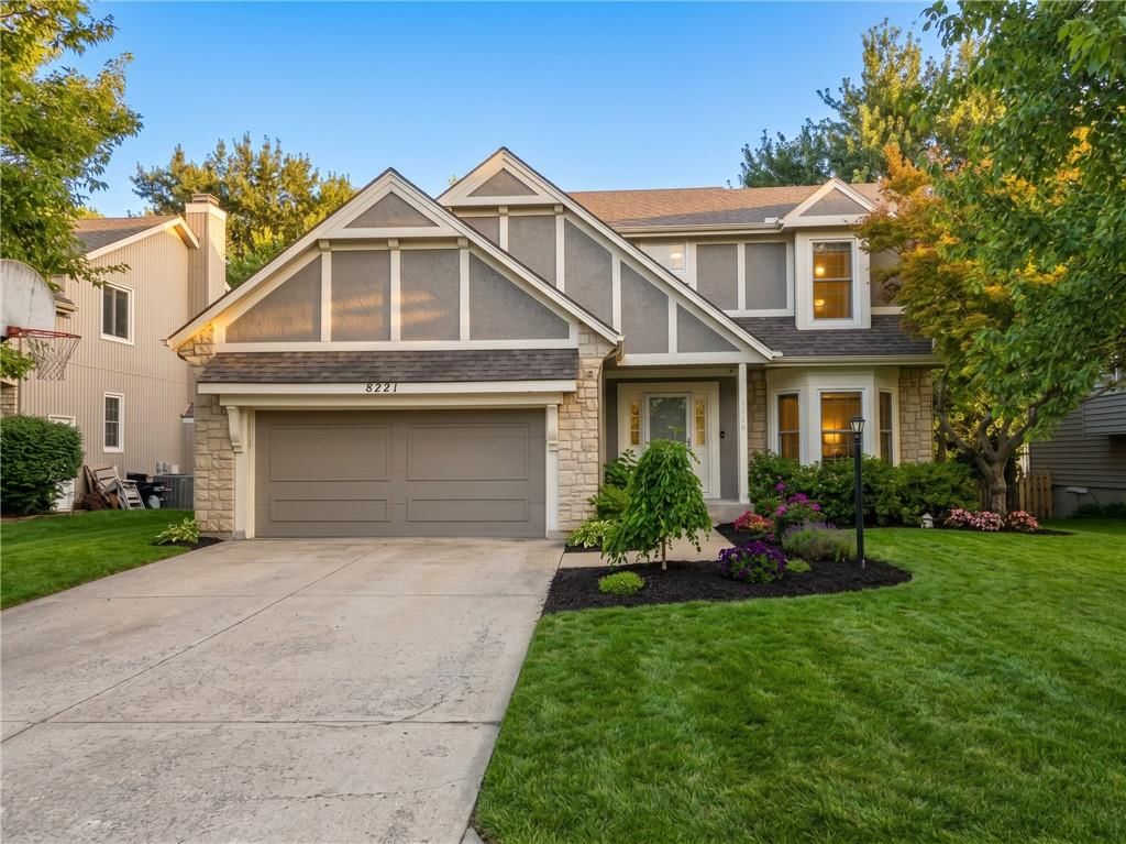 Stone exterior, mature trees and attached garage at 8221 W 152nd Terrace, Overland Park, KS 66223