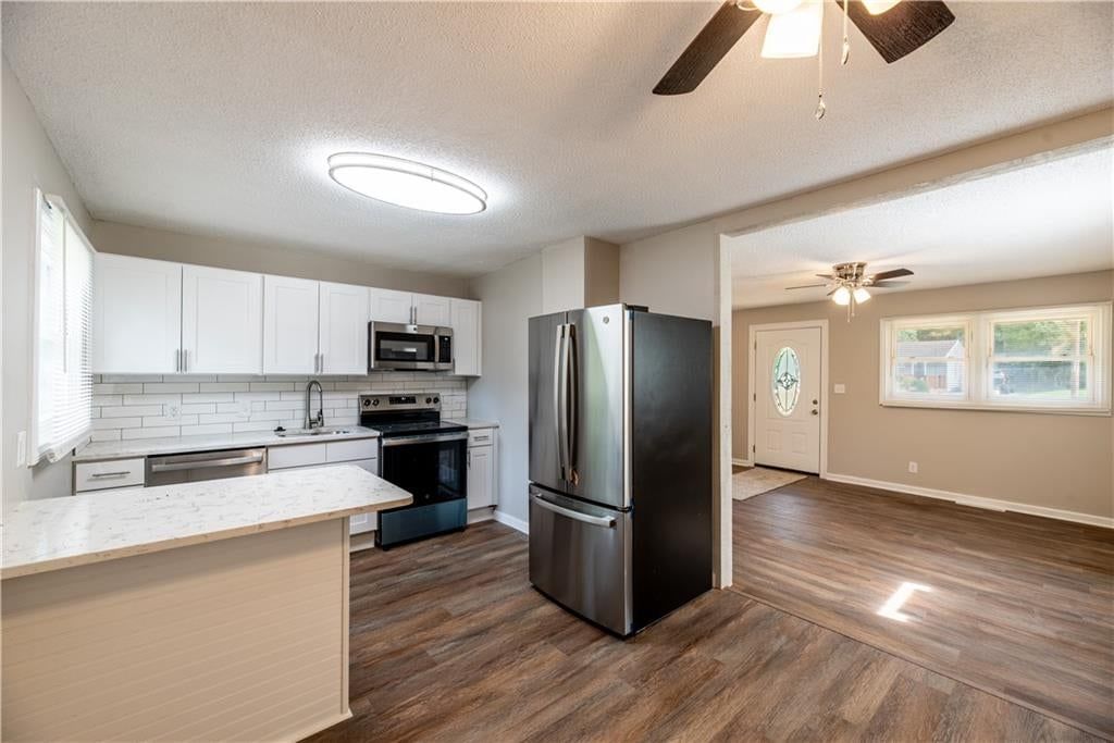 Open floor plan, kitchen island and white kitchen at 5126 N Corrington Avenue, Kansas City, MO 64119