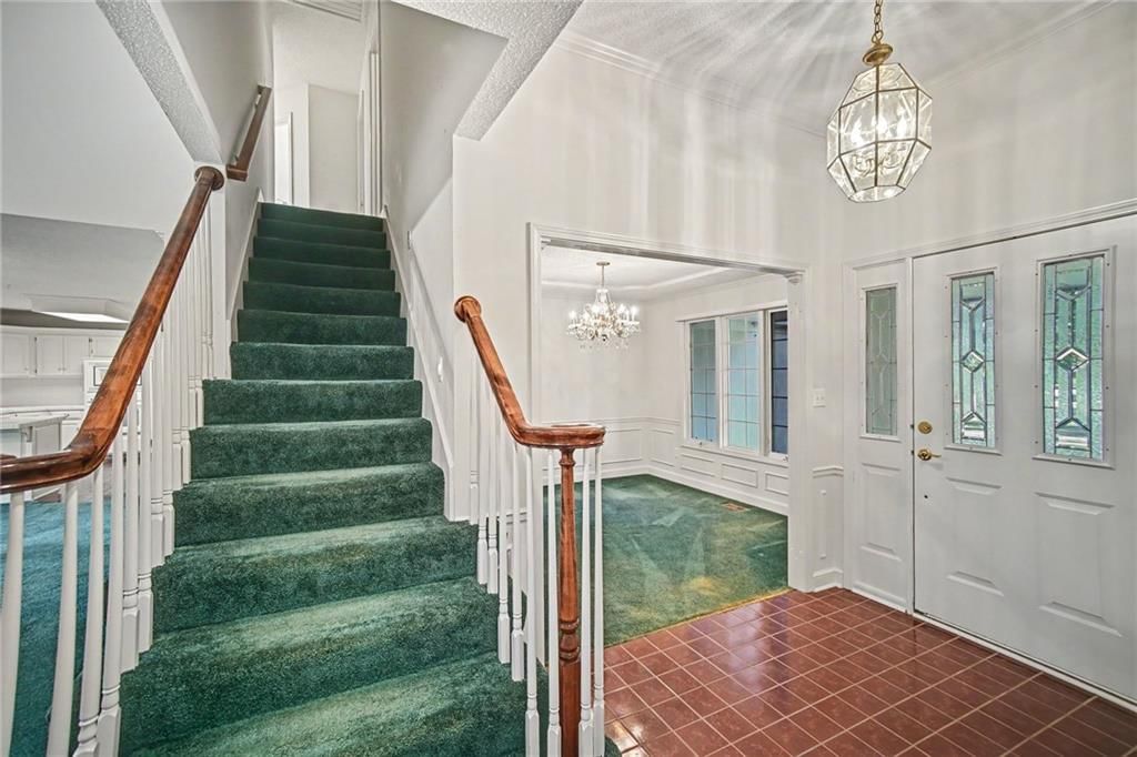 Statement lighting, wainscoting or board and batten and staircase at 24909 E Blue Mills Road, Independence, MO 64058