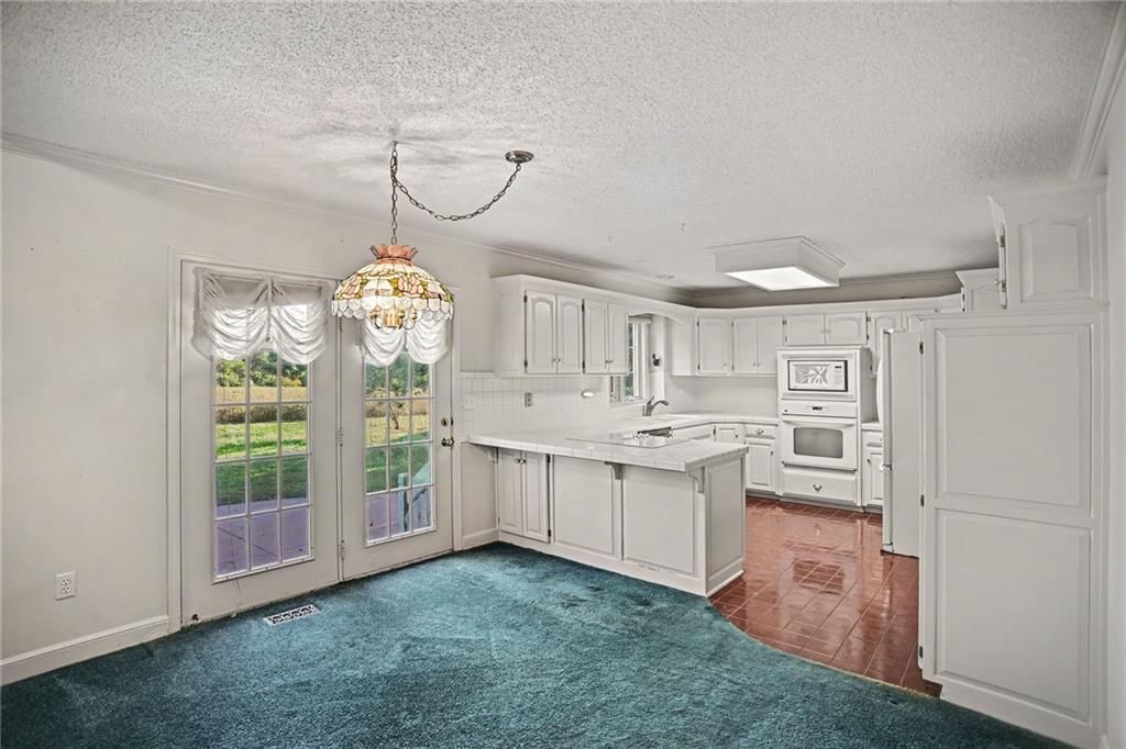 White kitchen, breakfast nook and white appliances at 24909 E Blue Mills Road, Independence, MO 64058