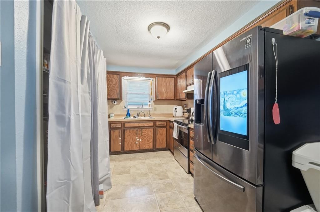 Stainless steel appliances, wood kitchen cabinets and electric range at 7415 NW 80th Terrace, Kansas City, MO 64152