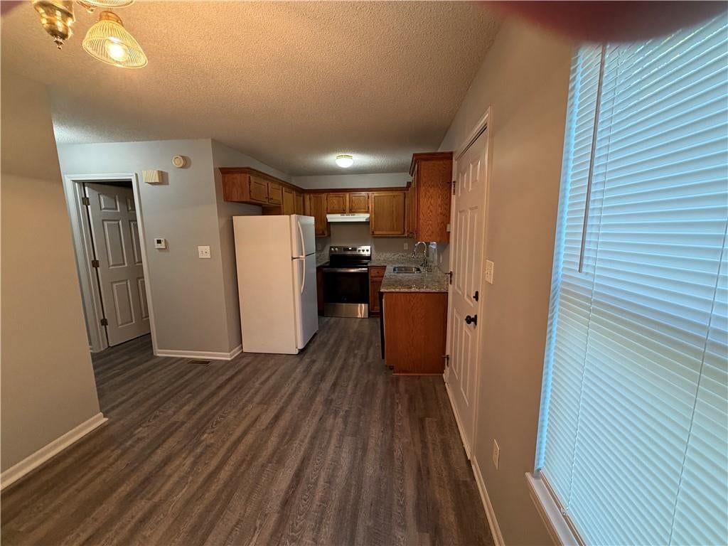 Granite counters, wood kitchen cabinets and electric range at 1700 W Walnut Street, Independence, MO 64050