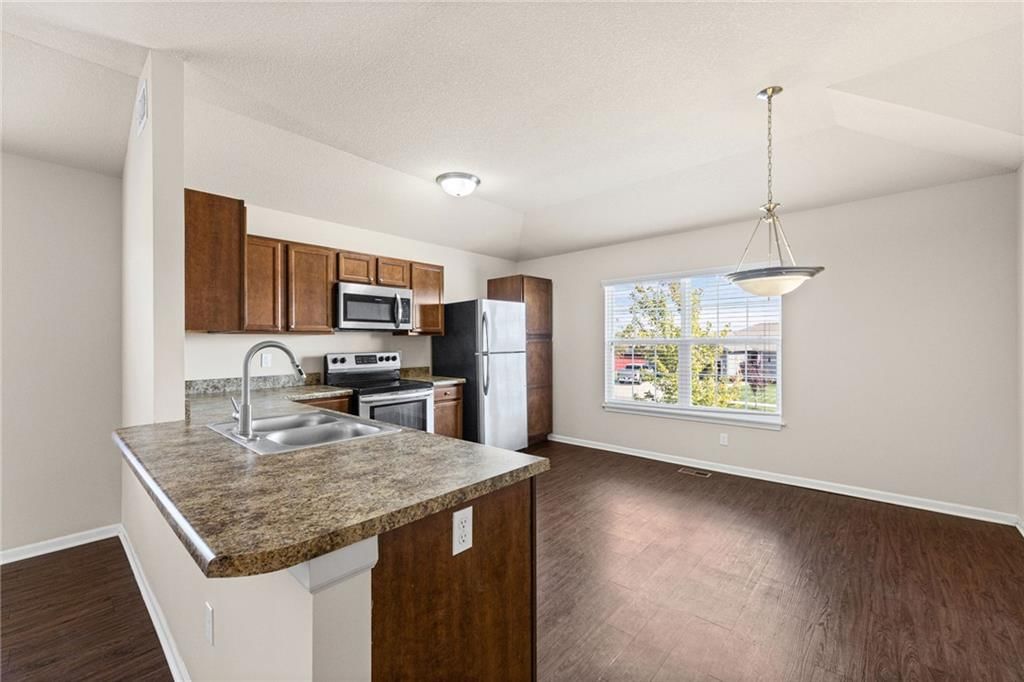 Stainless steel appliances, breakfast nook and wood kitchen cabinets at 17176 S Kill Creek Road, Gardner, KS 66030