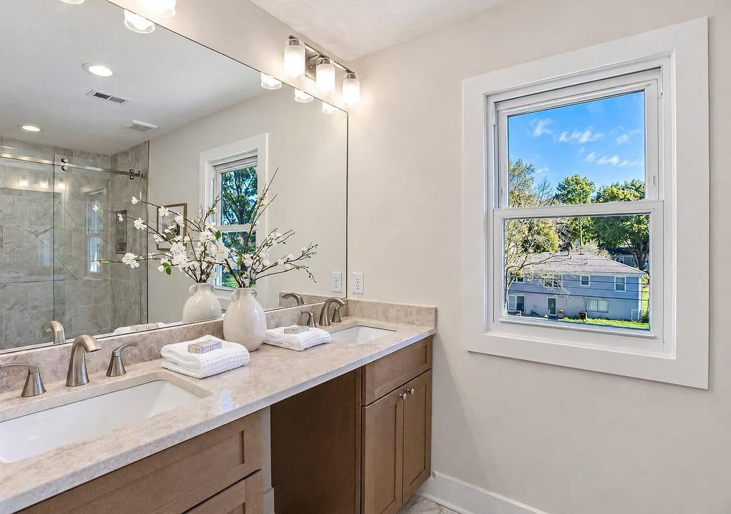 Double vanity, frameless glass shower and wood vanity at 9931 Woodson Drive, Overland Park, KS 66207